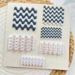 Assorted White and Navy Wavy Silicone Molds Placed on a Cream Board Atop a Woven Mat  Bling On