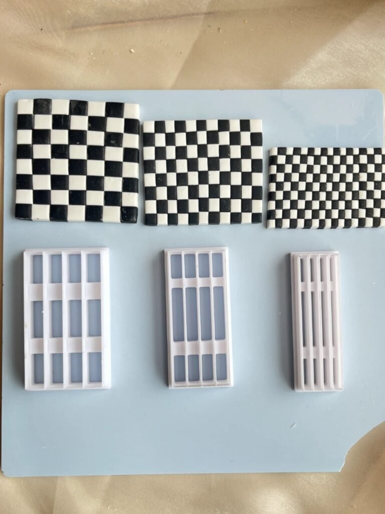 Three large white-and-black checkerboard tiles plus three white grid panels on a light blue surface, arranged in a row above the panels at left and center and right.