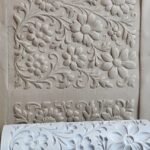 Decorative Embossed Floral Pattern on a Plaster Panel with Curling Vines and Flowers wall Relief Translation Note Ornate Floral Texture Present on Wall and Sample Roll  Bling On