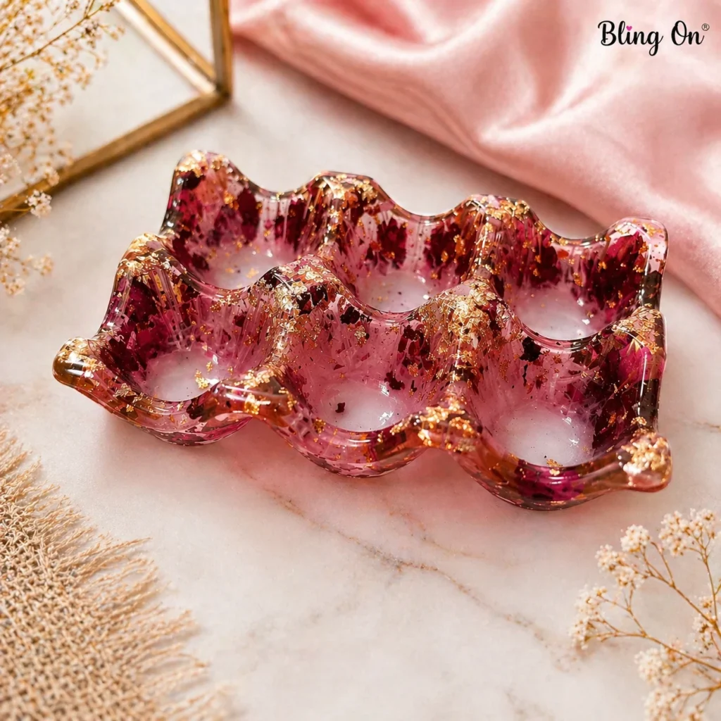 Pink resin tray with gold foil flakes and purple confetti, featuring wavy edges and placed on marble surface.