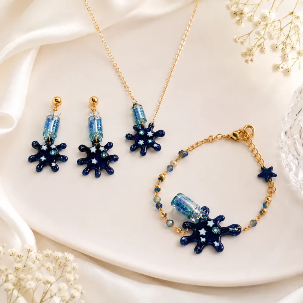 Gold-tone jewelry set with navy blue starburst pendants: matching necklace, earrings, and bracelet on cream fabric.