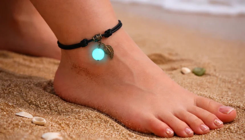 Barefoot on Sandy Beach Wearing a Black String Anklet with a Glowing Turquoise Charm and a Small Leaf Pendant Near Seashells  Bling On